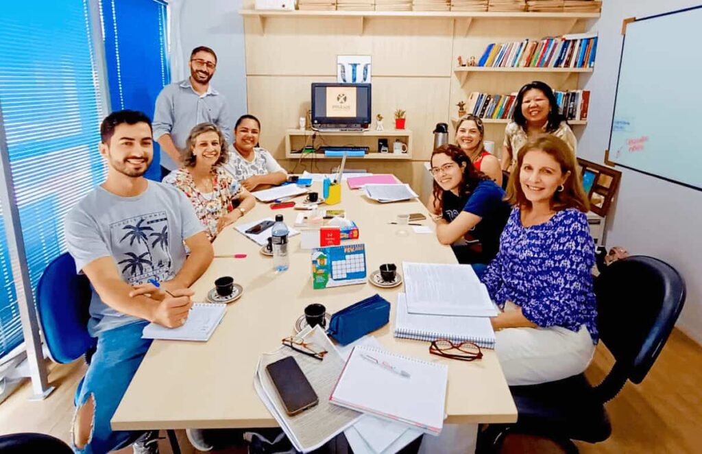 Psicólogos da clínica Práxis em reunião de equipe na sala de atendimento em Joinville